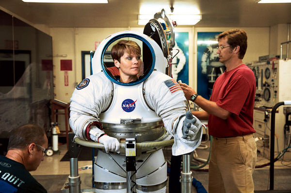 نرى رائدة الفضاء ماكلين وهي تحاول تجربة نموذج تجريبي من بدلة رواد الفضاء. تقول ماكيلين: "ارتداء بدلة الفضاء هو أمر شاق للغاية، إنه يشبه الدخول إلى طائرة صغيرة الحجم".