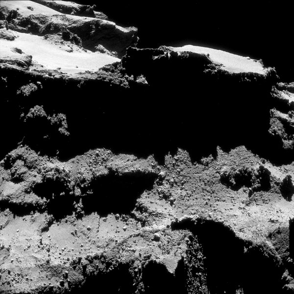 صورة ذات إطار واحد تم التقاطها بواسطة NAVCAM للمذنب 67P/C-G في 27 تشرين الأول/أكتوبر عام 2014 من على مسافة تبعد 9.8 كم من مركز المذنب. تمت معالجة الصورة بشكل طفيف بهدف إظهار التفاصيل على سطح المذنب. المصدر: ESA/Rosetta/NAVCAM – CC BY-SA IGO 3.0