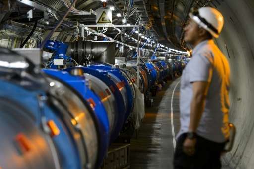 عالم ينظر إلى أحد الأقسام في مصادم الهادرونات الكبير أثناء الصيانة التي جرت في ميرن بالقرب من جنيف في 19 يوليو/تموز 2013.