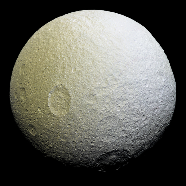 تُظهِر هذه الصورة الفسيفسائية مُحسَّنة اللون لقمر تيثيس مجموعةً من الملامح على نصف القمر التابع؛ حيث أن تيثيس مرتبط مع زحل بقوى مدية، ومن ثمّ فإن النصف التابع هو جانب القمر الذي يواجه دائماً عكس اتجاه حركته أثناء دورانه حول الكوكب. المصدر: ناسا/ مختبر الدفع النفاث (JPL)/ معهد علوم الفضاء (Space Science Institute).