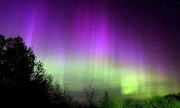 لوحة جميلة من أشعة الشفق تنتشر في السماء من جهة الشمال في 12 مايو في دولوث-مينيسوتا. تنتج ألوان الشفق على الأرض عند إثارة ذرات النيتروجين والأكسجين بواسطة الرياح الشمسية عالية السرعة.