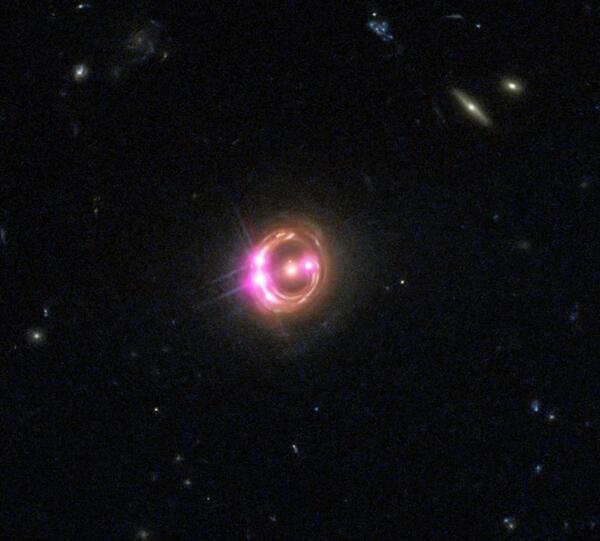 كوازار (quasar) بعيد للغاية يظهر الكثير من الأدلة على وجود ثقب أسود هائل في مركزه. كيف أصبح هذا الثقب الأسود بهذه الضخامة بهذه السرعة هو موضوع جدل علمي، لكن اندماج الثقوب السوداء الأصغر التي تشكلت من الأجيال الأولى من النجوم قد توفر الأصول اللازمة. تتفوق العديد من الكوازارات في سطوعها حتى على أكثر المجرات سطوعًا. حقوق الصورة: X-ray: NASA/CXC/Univ of Michigan/R.C.Reis et al; Optical: NASA/STScI