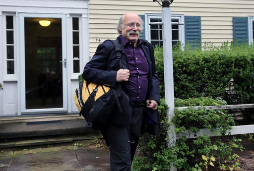 تظهر الصورة أستاذ الفيزياء بجامعة برينستون دنكان هالدين يغادر منزله بعد أن أعلن عن فوزه بجائزة نوبل في الفيزياء لعام 2016، ويقاسمه الجائزة كل من ديفيد ثاوليس ومايكل كوستيرليتز.  المصدر : (AP Photo/Mel Evans)