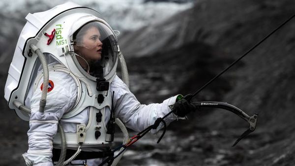 صعدت هيلجا كريستين على وجه أحد الأنهار الجليدية مرتديةً بدلة الفضاء التناظري المريخية. (حقوق الصورة: Dave Hodge/Unexplored Media)