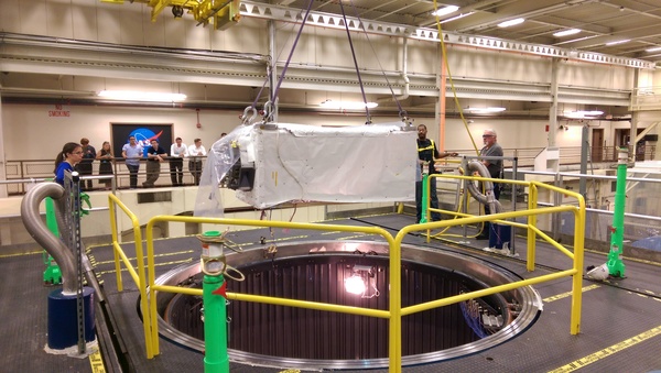 ينزل الفنيون جهاز الكشف ISS-CREAM داخل حجرة تحاكي البيئة الفضائية، خلال اختبار مستوى النظام، في مركز غودارد لرحلات الفضاء، في صيف 2015. مصدر الصورة: المختبر الفيزيائي للأشعة الكونية في جامعة ميريلاند.