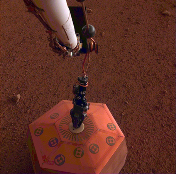 صورة لمقياس الزلازل الخاص بمركبة إنسايت بعد أن وضعته على سطح المريخ في 19 ديسمبر/كانون الأول 2018. وكانت هذه أول مرةٍ يتم فيها نشر أداةٍ علمية مباشرة ًعلى سطح الكوكب الأحمر. حقوق الصورة: NASA/JPL-Caltech