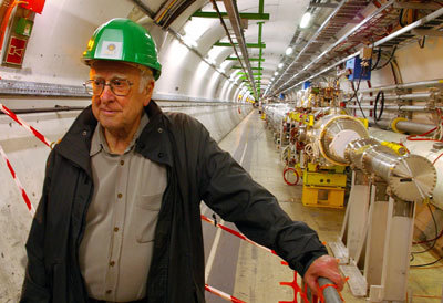 بيتر هيغز Peter Higgs -الشخص الذي سمي جسيم بوزون هيغز باسمه- وهو يتجول في مصادم الهادرونات الكبير.  حقوق الصورة : Alan Walker/AFP/GettyImages .
