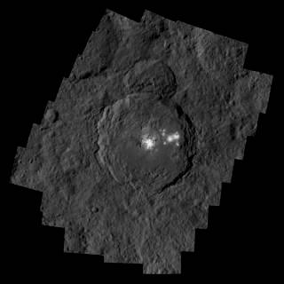 تظهر فوهة أوكيتور البركانية بقياس 57 ميلاً (92 كم) عرضاً و2.5 ميل (4 كم) عمقاً، والتي تحتوي على ألمع منطقة في سيريس.   مصدر الصورة: NASA/JPL-Caltech/UCLA/MPS/DLR/IDA/PSI
