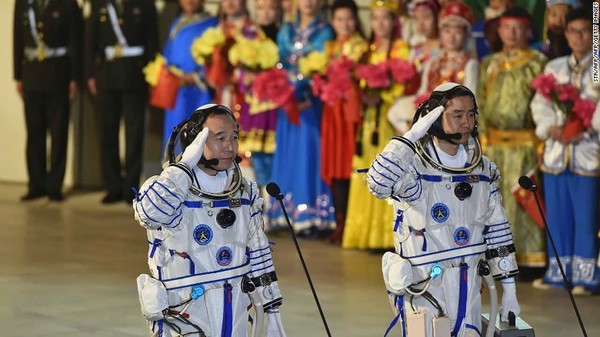 صورة لرائد الفضاء جيني هايبن Jing Haipeng (على اليسار) ورائد الفضاء سيي دو Chen Dong أثناء تأديتهما للتحية خلال مراسم إرسالهما في مهمة شنخاو11 (Shenzhou-11) الفضائية المأهولة من مركز جي كويان Jiuquan لإطلاق الأقمار الصناعية في مدينة جي كويان ، الصين.