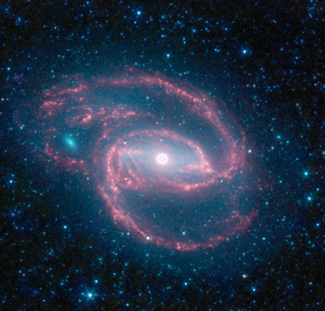 صورة لمجرةٍ مُلتفّة التقطها تلسكوب سبتزر الفضائي Spitzer Space Telescope التابع لوكالة ناسا يظهر في وسطها شيءٌ يُشبه العين. هذه العين هي ثُقب أسود عملاق تُحيط به حلقة من النجوم.  المصدر: وكالة ناسا/مختبر الدفع النفاث- معهد كاليفورنيا للتكنولوجيا